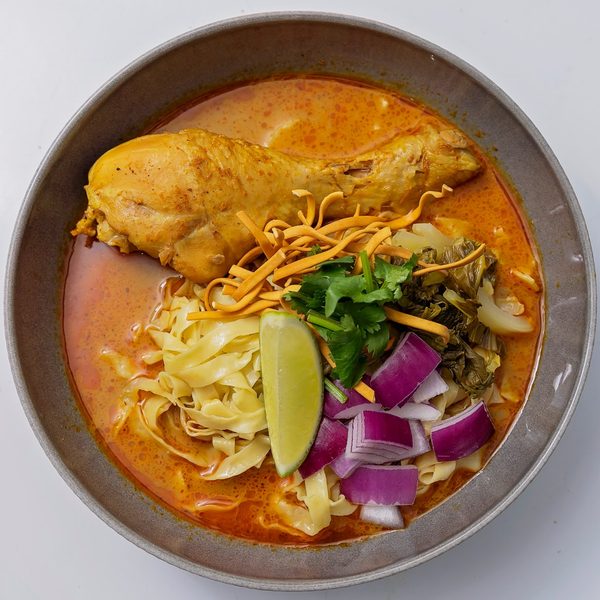 Bowl of chicken khao soi with egg noodles and crispy noodles on top